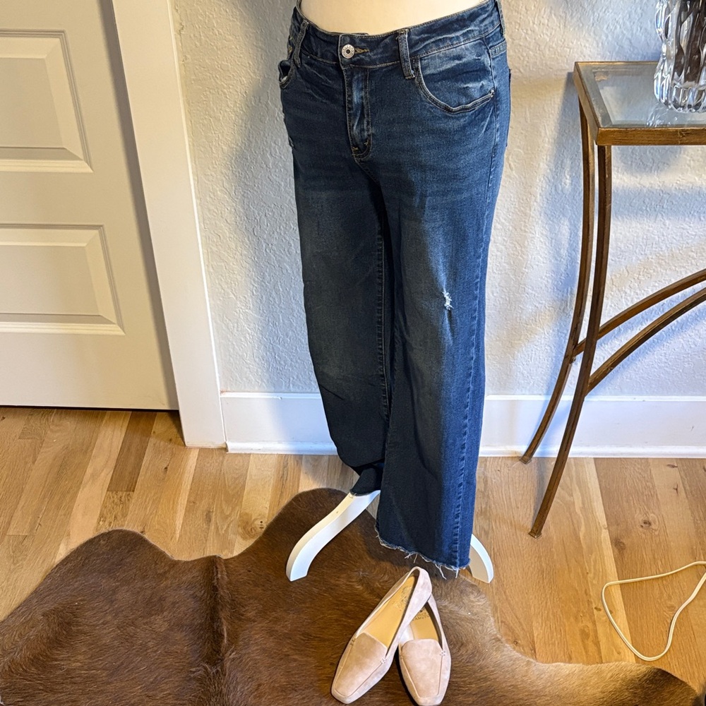 Lightly distressed denim jeans in medium wash, with a raw hem. Size 6.